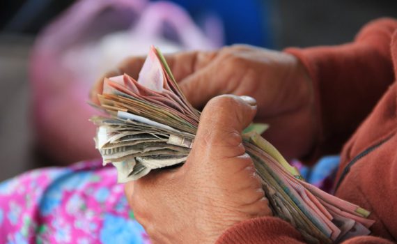 The hands of an old lay counting money